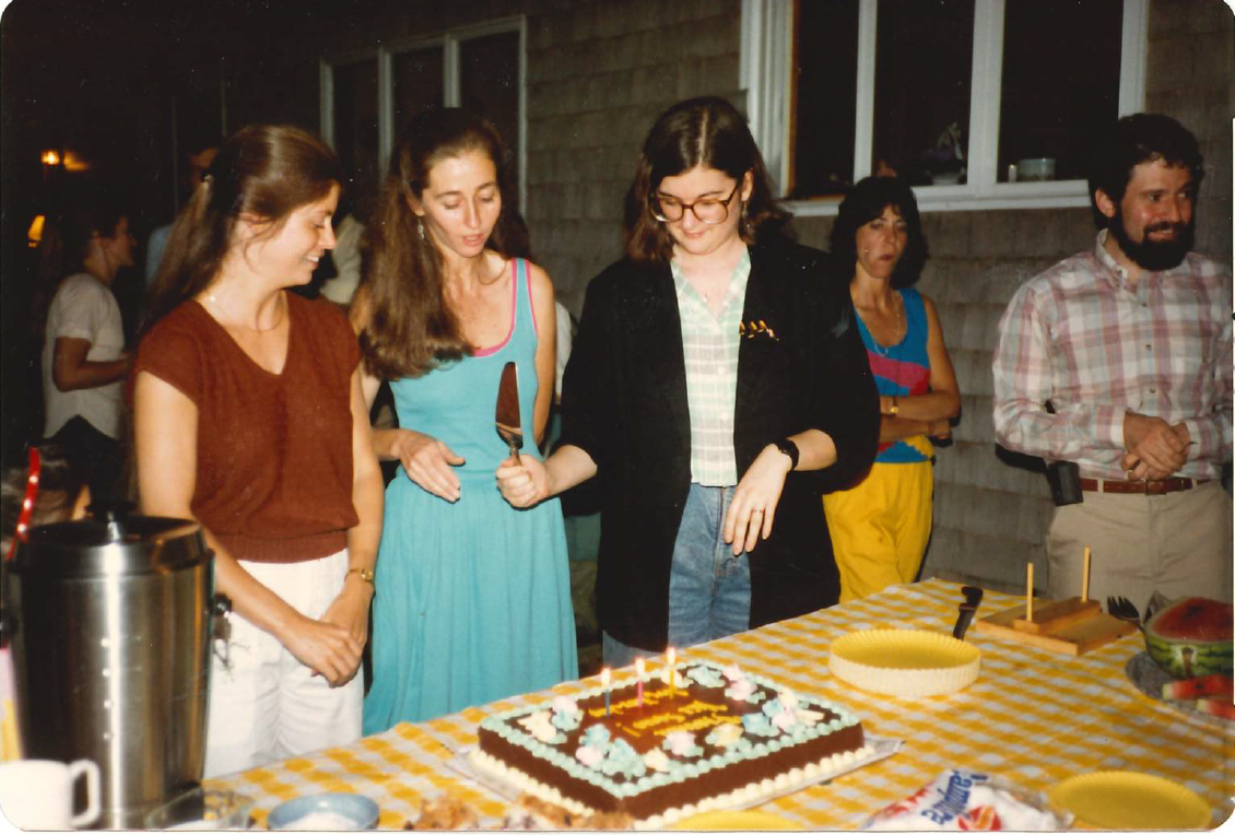 three people cutting cake