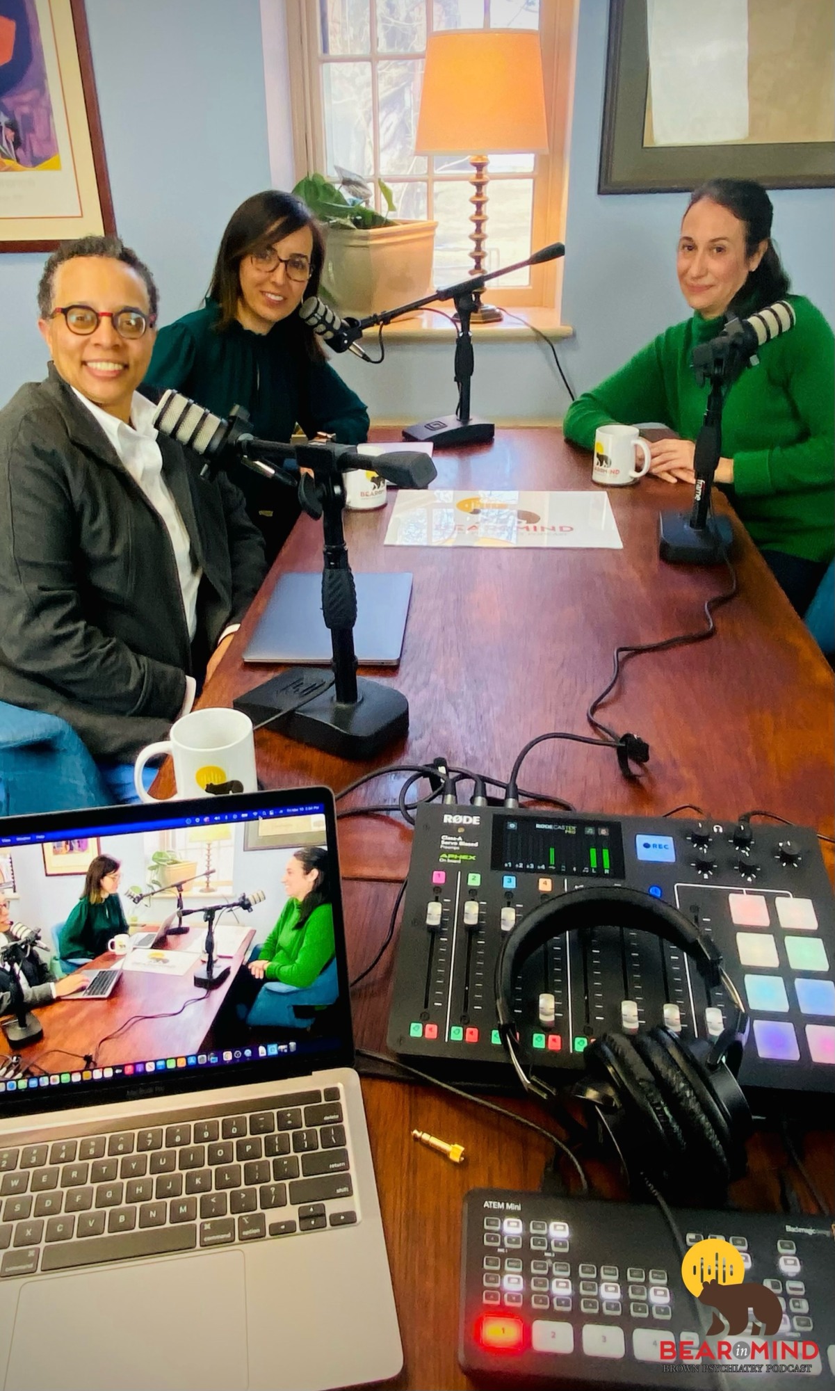 three people sitting in front of microphones and audio equipment