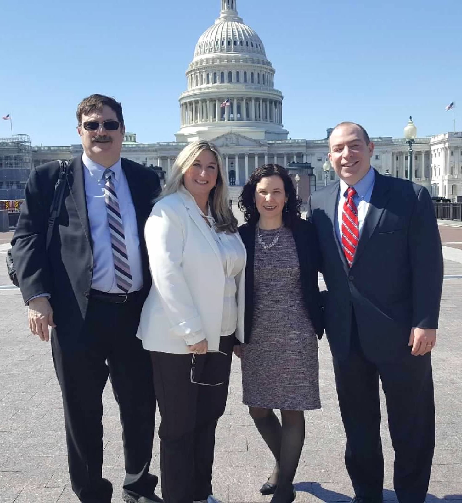 four people in front of the U.S. Capitol Building
