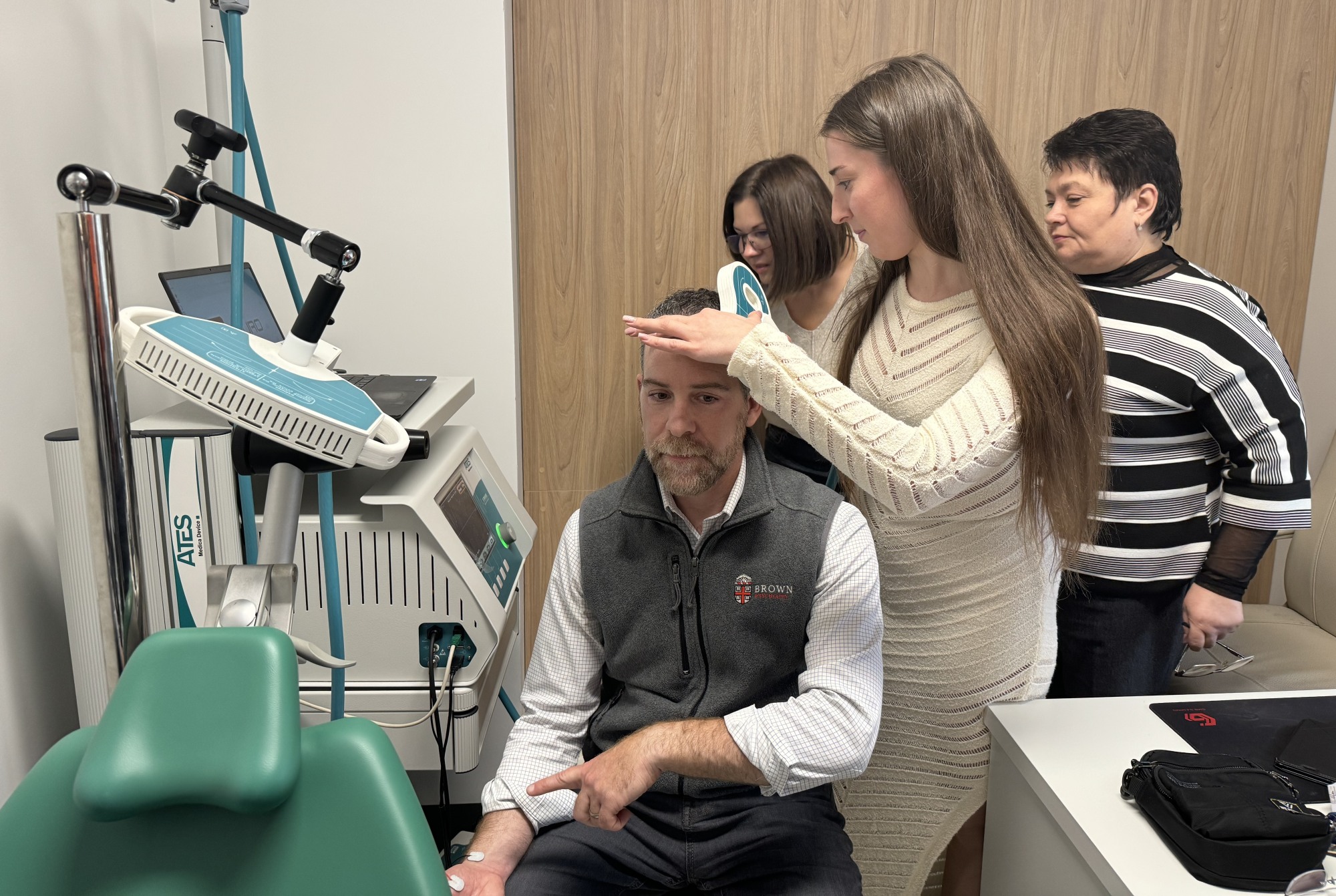 Woman applying metal coils to Philip's head