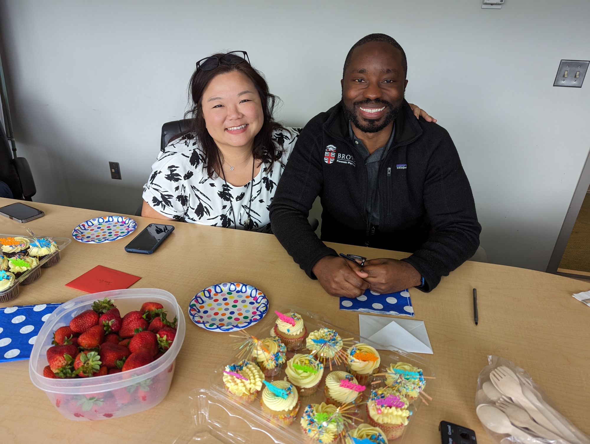 two people at table with cupcakes and strawberries