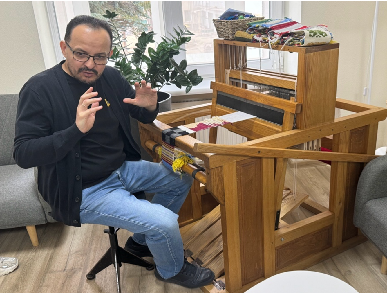 Man sitting at a loom with foot pedals