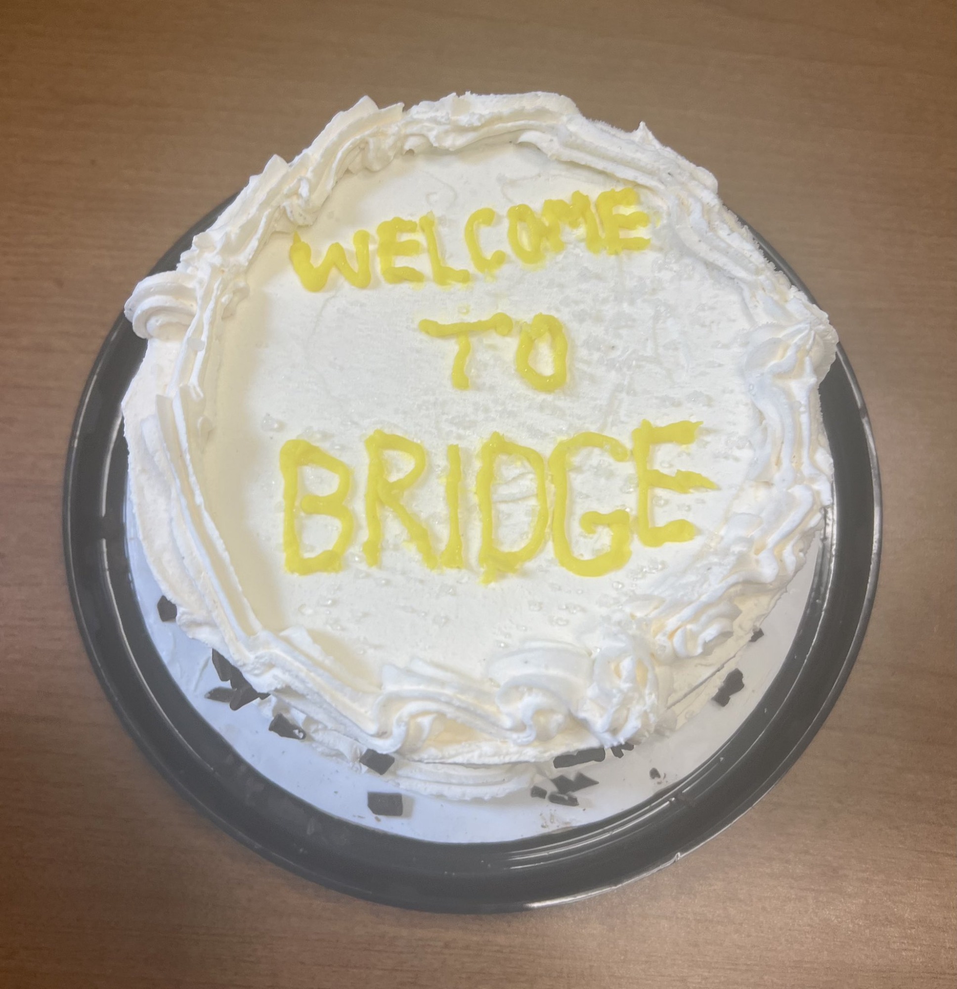 cake with "Welcome to BRIDGE" written in icing
