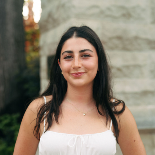 Headshot of Paloma Jourdes Ferdman outdoors in front of a stone building.