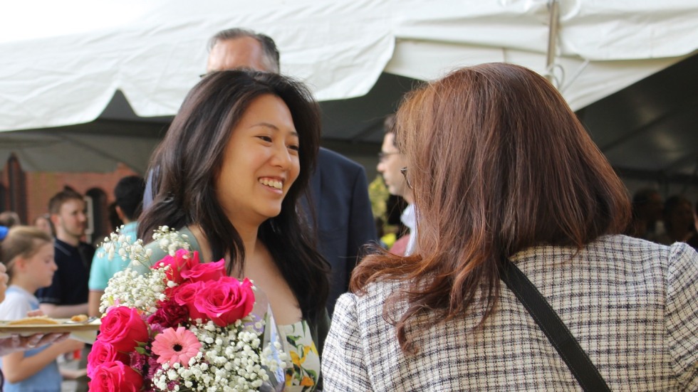 graduate holding flowers