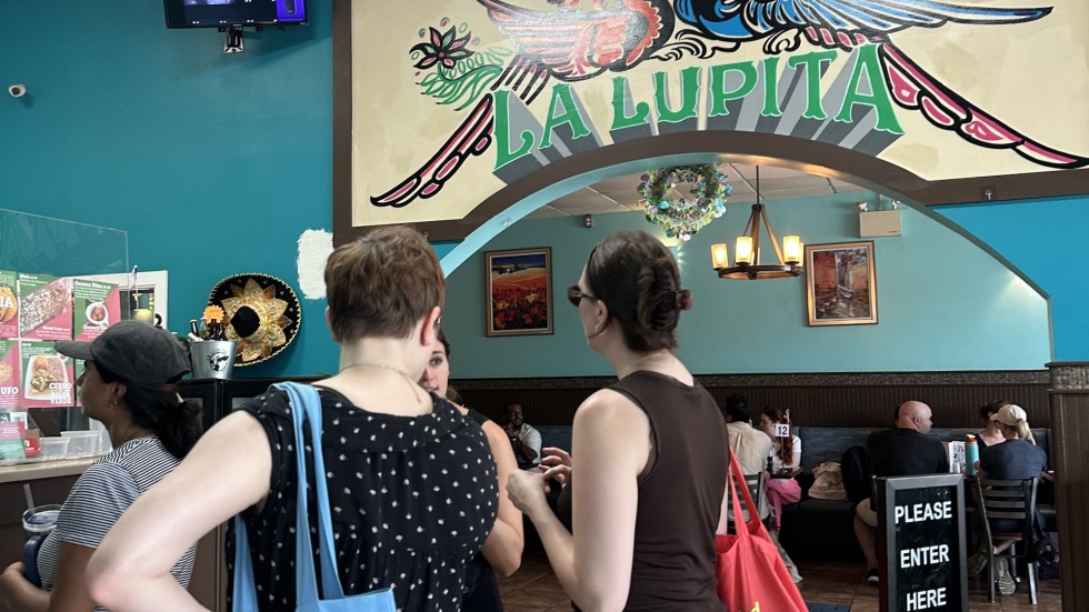 people beneath La Lupita sign