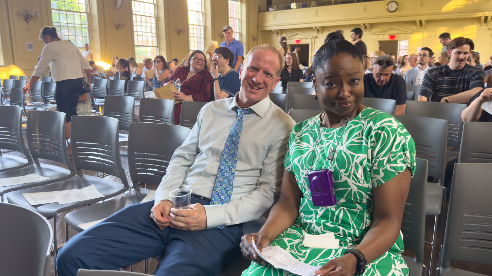 two people sitting in foreground of audience