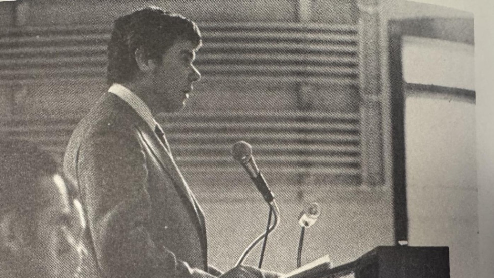 Ben Feather, MD, PhD, in profile at podium
